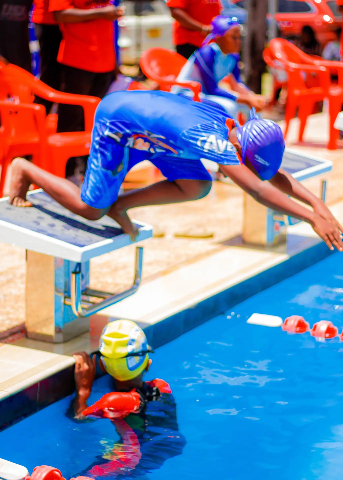 A swimmer dives off the block at the start of a race.