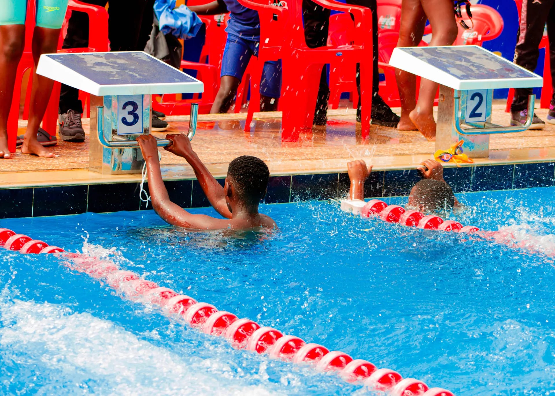 Swimmers touching the wall at the end of their race.