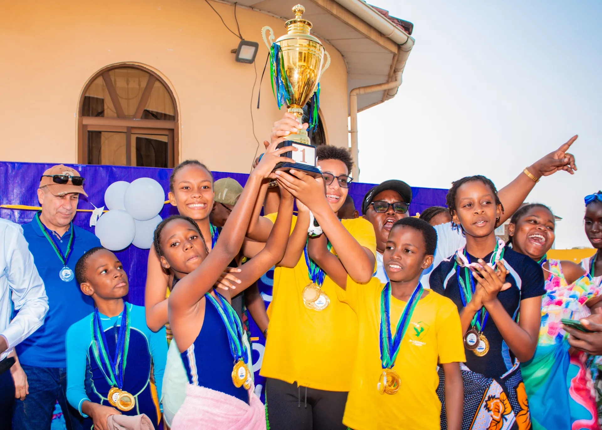 Milestones Academy swimming champions celebrating with their trophy in 2026